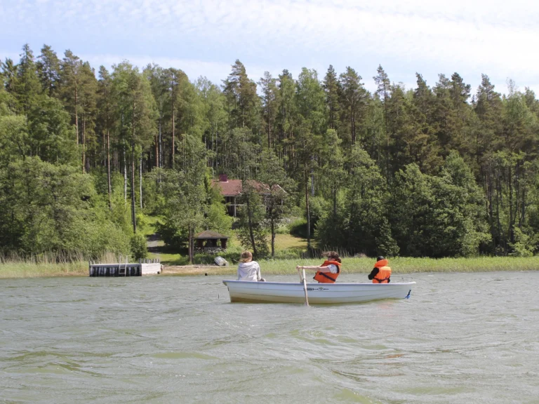 Mother is rowing and children are fishing in front of Iso-Keisari spacious seaside villa